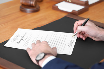 Male notary signing marriage contract, closeup