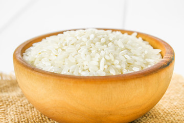 Grains of raw white rice on a white wooden table of boards. Ingredients for cooking.