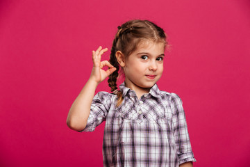 Happy little girl child showing okay gesture.