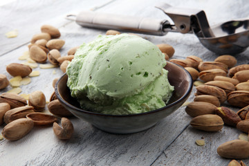 scoop of pistachio ice cream with pistachios on wooden background
