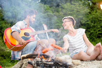 Baking sausages at campfire