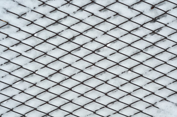 Texture of a metal grid in the snow