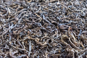 Dried black tea leaf background close up photo