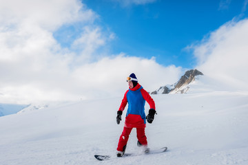 Fototapeta na wymiar Stylish male athlete snowboarder rides on a blackboard on the snow