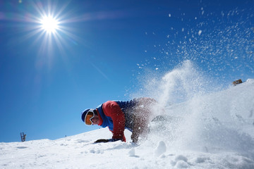 Naklejka na ściany i meble male athlete snowboarder falls on snow