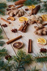 Traditional spices cinnamon, anise stars, ginger, dried oranges on the wooden background with Christmas tree branches still life. Christmas background composition with new year decorations. Horizontal