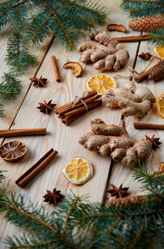 Traditional spices for bakery cinnamon, anise stars, ginger, dried oranges on the wooden background with Christmas tree branches. Christmas background composition with new year decorations. Horizontal