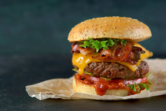 Burger with cheese and bacon on a dark background