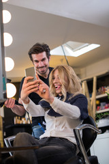 Hairdresser and his client making selfie