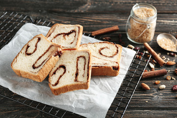 Baking rack with delicious cinnamon roll cake on table