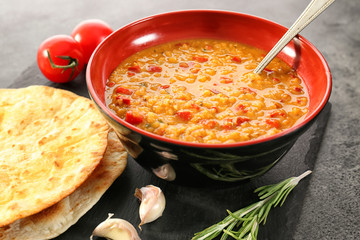 Bowl with tasty lentil soup on slate plate