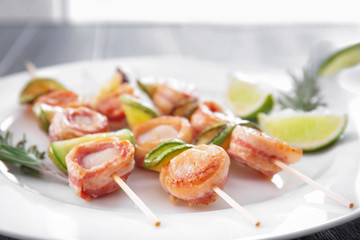 Plate with bacon wrapped scallops on table