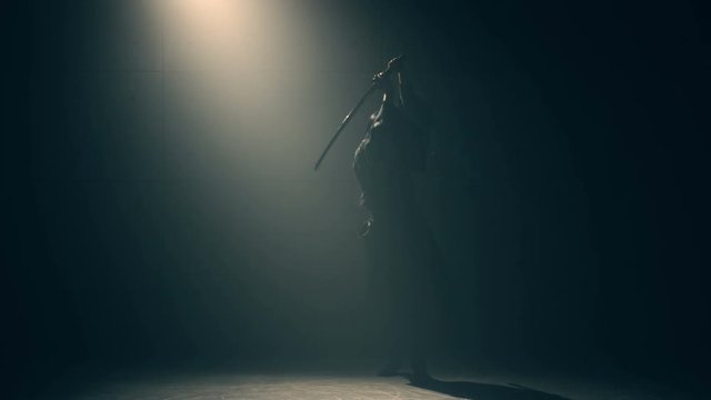 Martial arts Concept. Woman in kimono practicing with katana