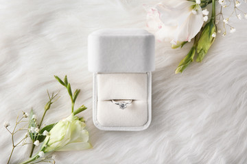 Box with luxury engagement ring on fur, top view - obrazy, fototapety, plakaty