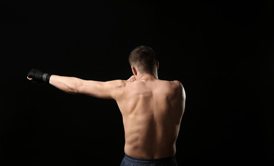 Attractive young boxer on black background
