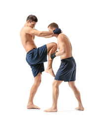 Fototapeta na wymiar Attractive young kickboxers fighting on white background