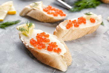 Tin can with delicious red caviar, dill and sandwich on table