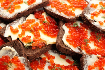 Tin can with delicious red caviar, dill and sandwich on table