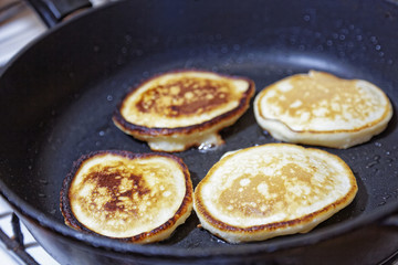 Sweet pancakes are fried in a frying pan. Home kitchen. Preparation of homemade food.