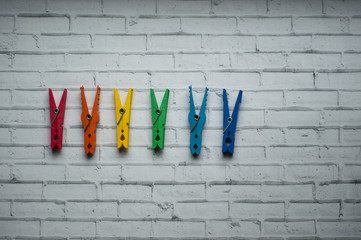 Colorful clothes pegs on white background.