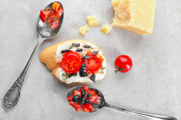 Tasty bruschetta with olives and tomatoes on grey background