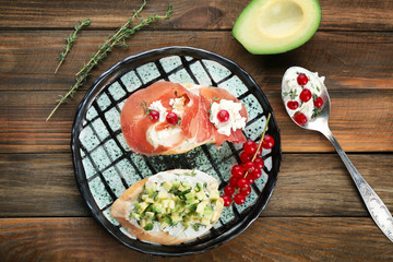 Plate with tasty bruschettas on table