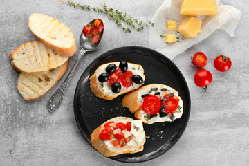 Plate with tasty bruschettas on table