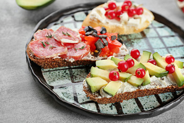 Plate with tasty bruschettas on table