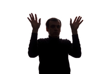 Innocent young man looking up with hope and request - silhouette