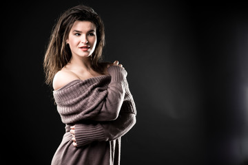 Photo of beautiful smiling woman in warm knitted dress, copy space