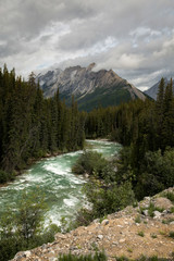 Raging river water with view of the mountain and cloudy sky