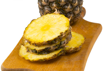 Ripe pineapple and pineapple slices on a wooden background tropical fruits