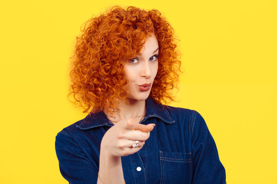 It's you! portrait of a beautiful woman redhead curly 80's retro style pointing at you camera happy isolated yellow background wall. Body language, gestures, psychology.
