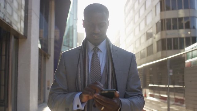 Successful business man walks using his phone, in slow motion