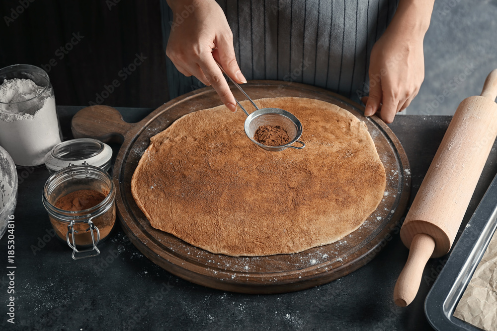 Wall mural woman preparing dough for cinnamon buns in kitchen