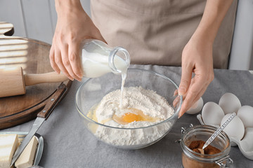Woman preparing dough for cinnamon buns in kitchen