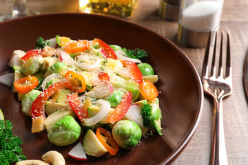Plate with yummy brussel sprouts salad on table, closeup