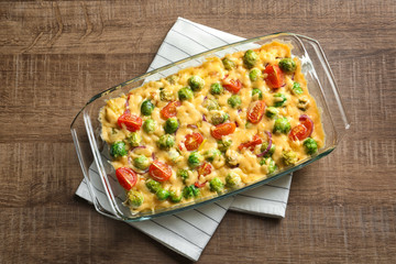 Baking dish with yummy brussel sprouts casserole on wooden table