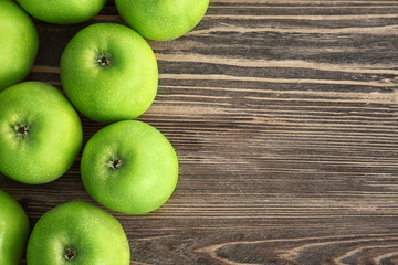 Fresh green apples on wooden background