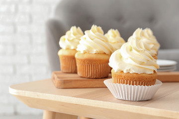 Tasty cupcakes on table