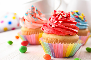 Tasty colorful cupcakes on table