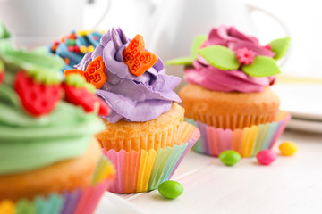 Tasty colorful cupcakes on table