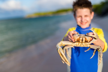 Teen age boy holding crab