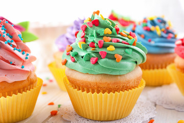Tasty colorful cupcakes on table