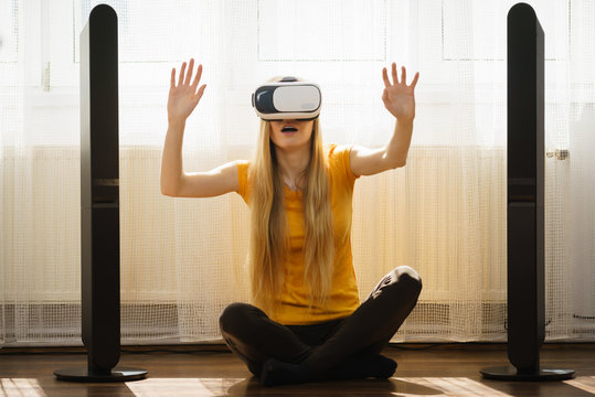 Girl wearing virtual reality goggles at home