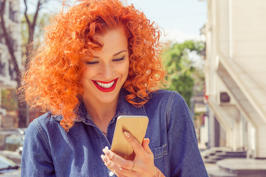 Young Woman in sinamay sun hat  Busy with her Mobile Phone While Walking near the park lake.  Lady in hat at mobile by the sea.