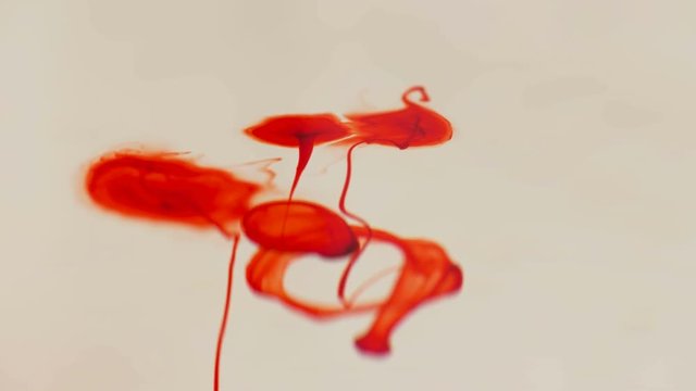 drops of red liquid similar to blood in the water