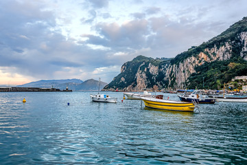 Fototapeta na wymiar Boats in Capri island main harbor under cloudy skies
