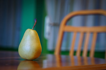 Fresh pear on wooden table with wooden chair in background