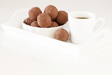 Homemade chocolate vegan truffles. Served with white dishes. Light background. Selective focus.
